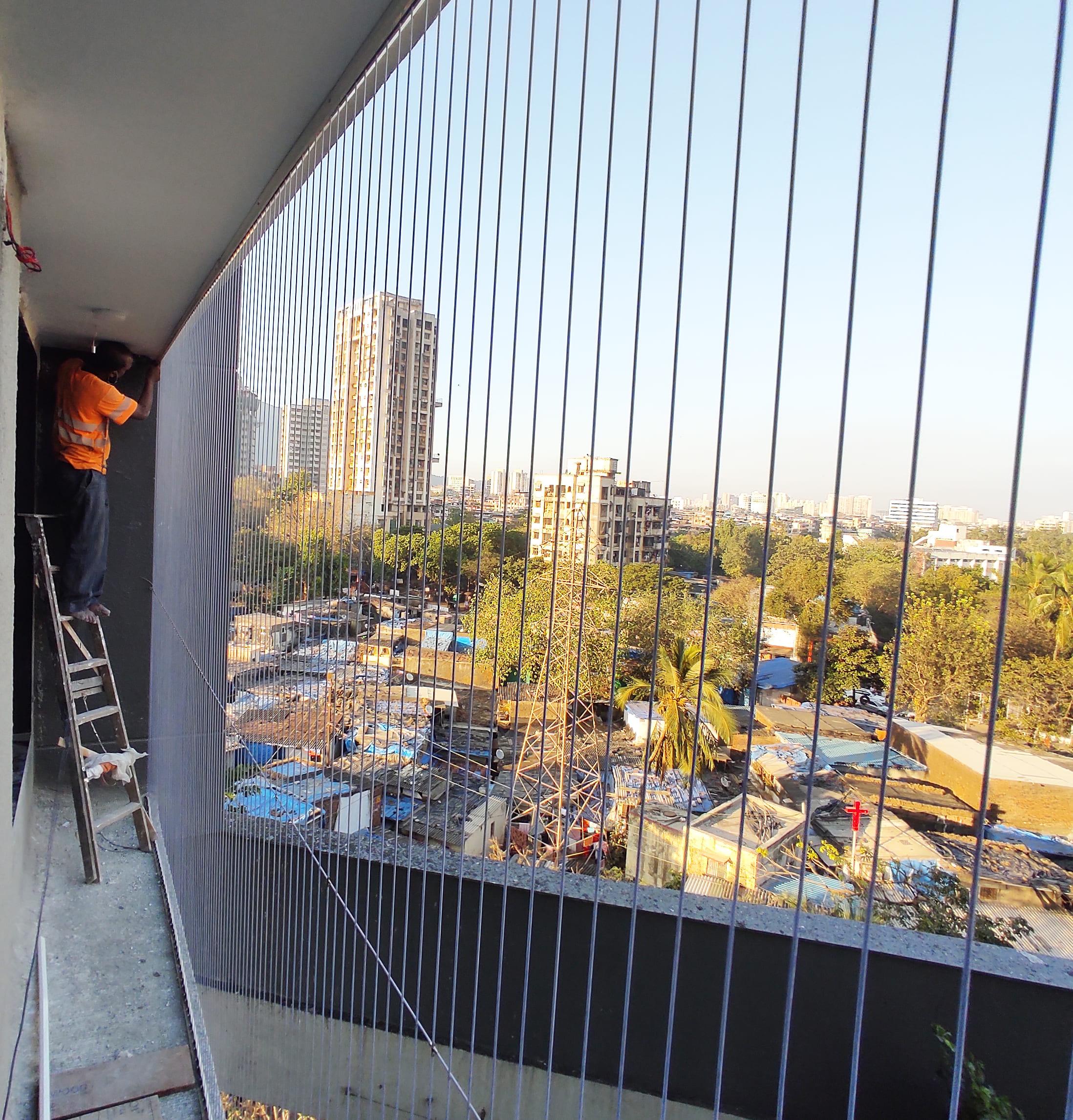 Invisible grill fitted to a high-rise apartment balcony with a minimal visual profile.