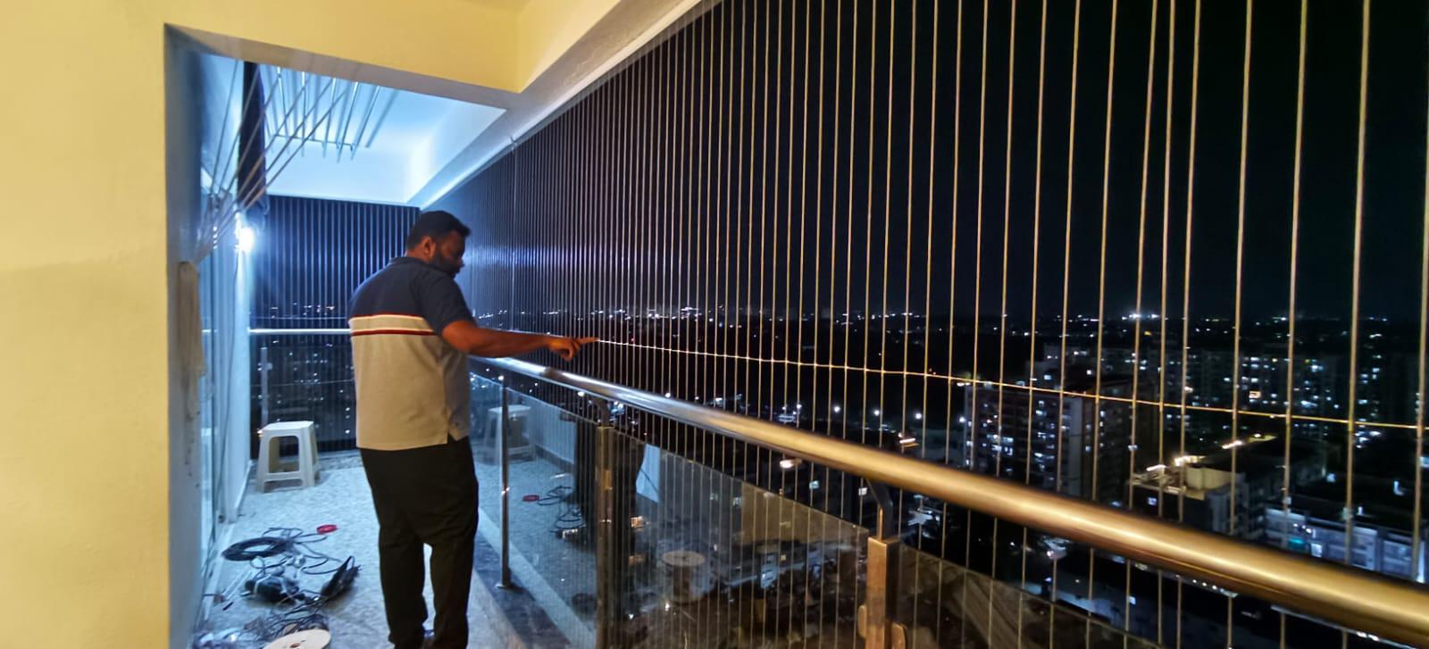 Technician inspecting a completed invisible grill installation for tension and finishing quality.